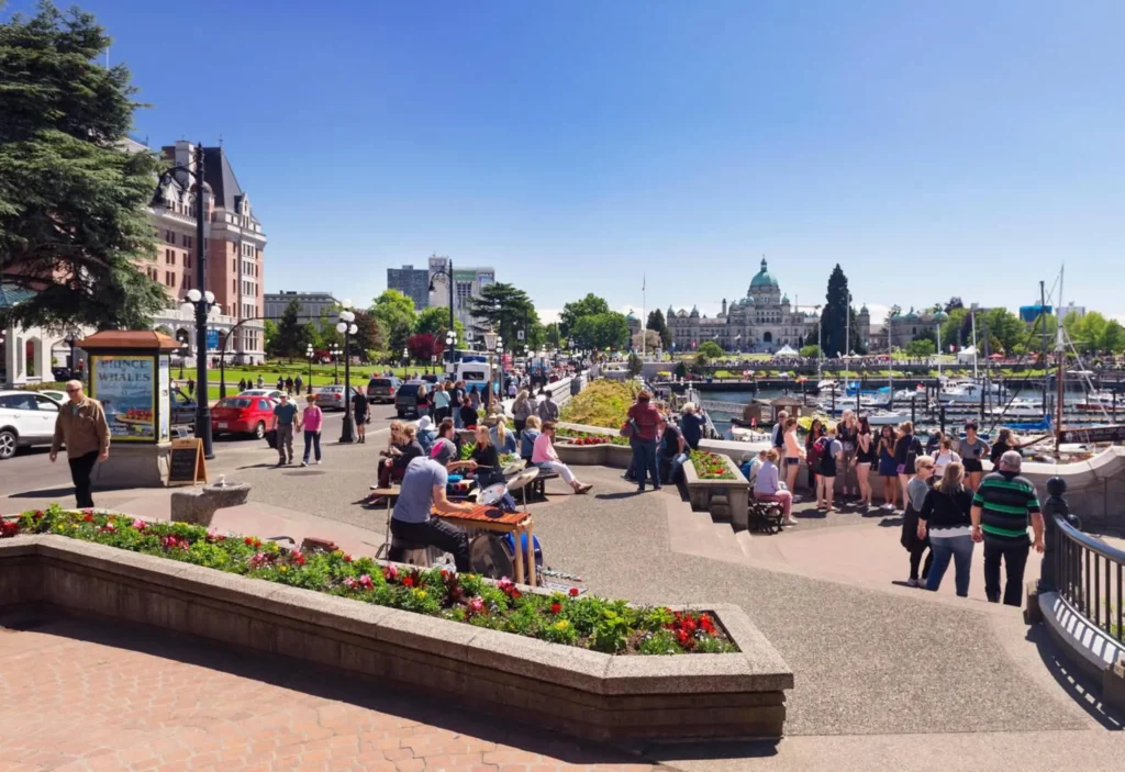 People in downtown Victoria, BC on a sunny summer day listening to a drummer, street musician.