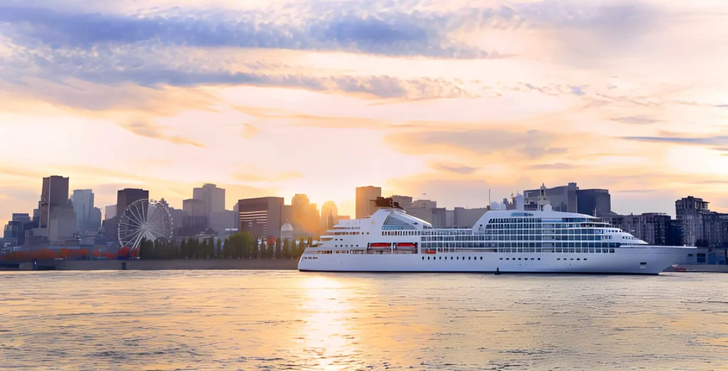 Cruise boat sailing at sunset on St. Lawrence River with skyline of Montreal