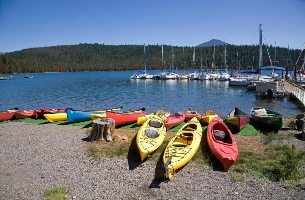 Kayaks sailboats and a view of Elk Lake along the Cascade Lakes Highway near Bend Oregon